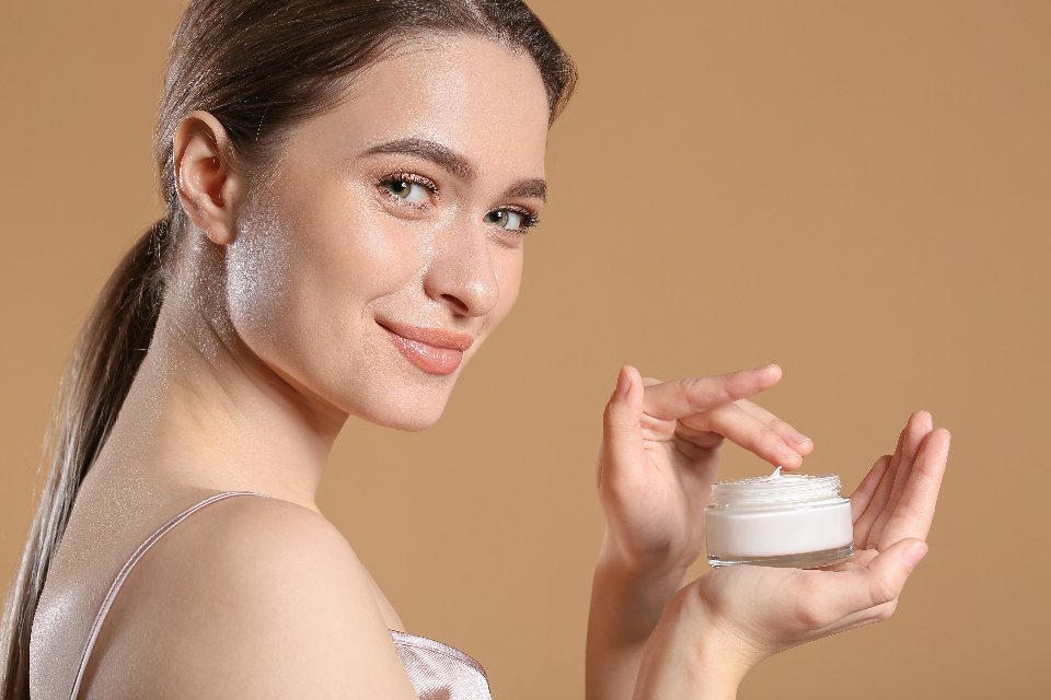 Cầm hũ kem dưỡng trên tay